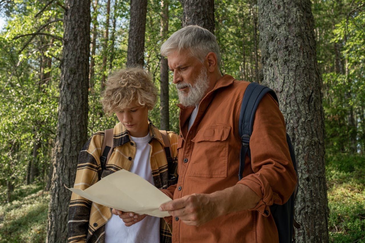 Father and son read a map on a hiking trail