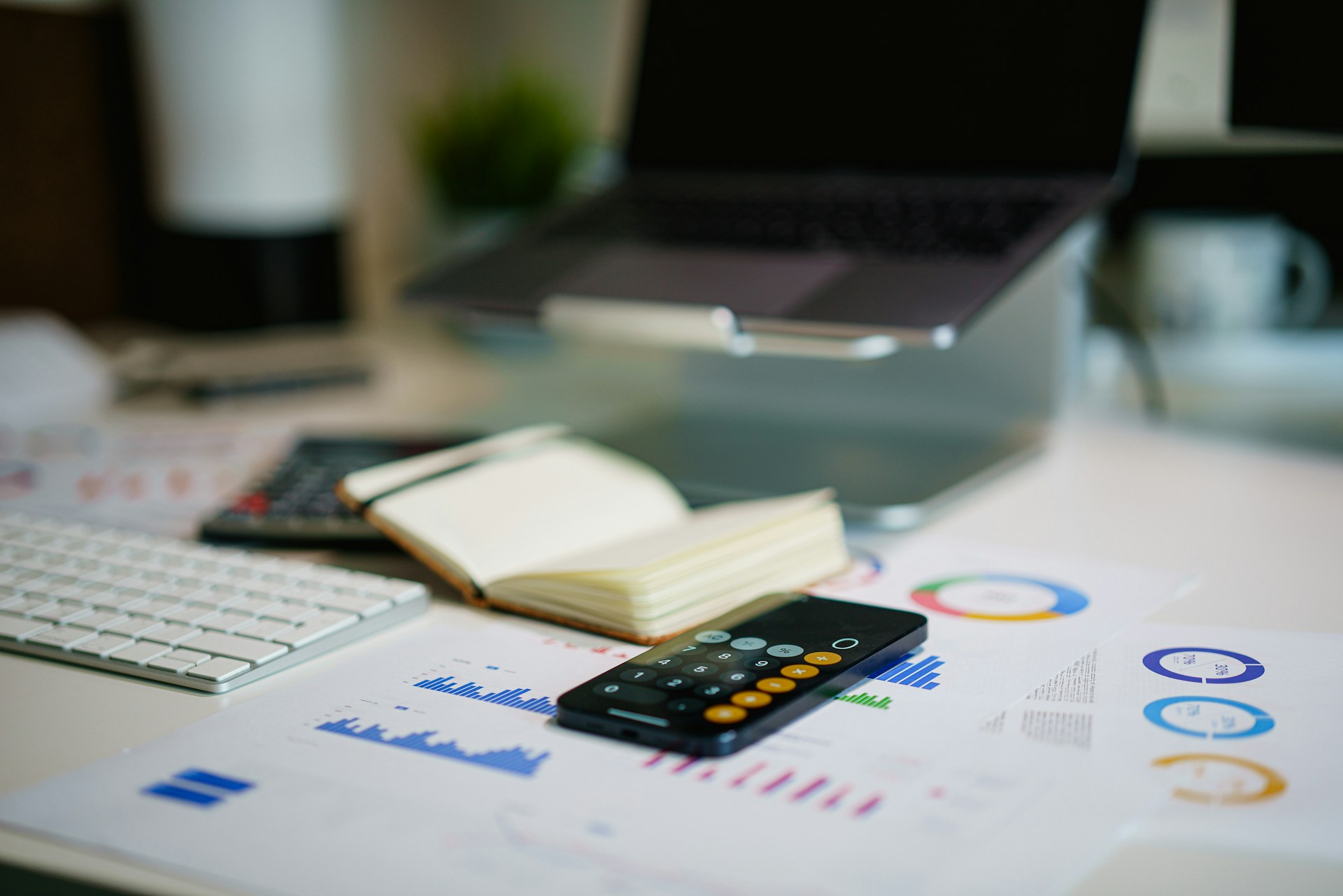 Calculator and paperwork with charts and costs