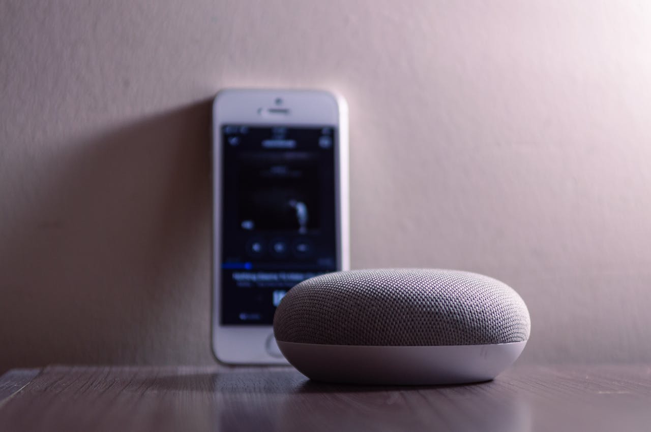 Close up of a smart speaker and smart phone on a table>